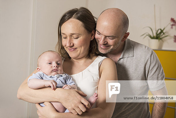 Portrait of happy family with baby boy at home