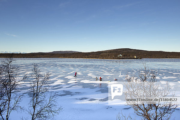 Menschen beim Schlittschuhlaufen auf einem zugefrorenen See