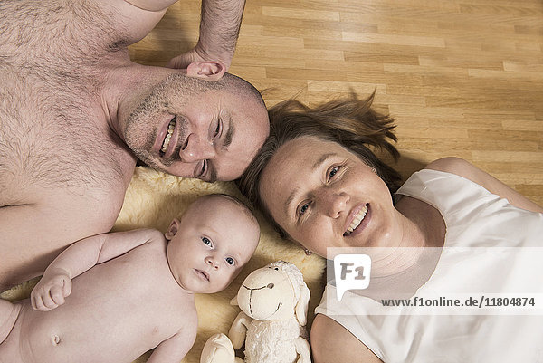 Porträt der Eltern auf dem Holzboden mit einem kleinen Jungen