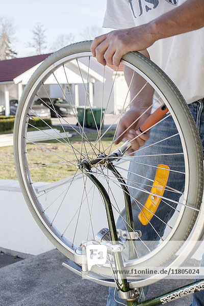 Mann repariert ein Fahrradrad