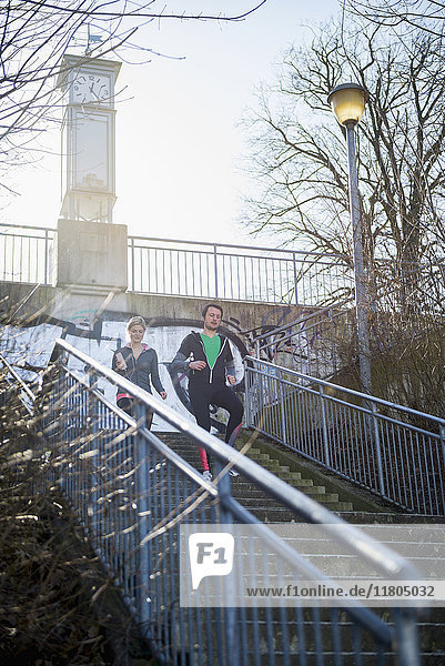 Man and woman jogging down stairs