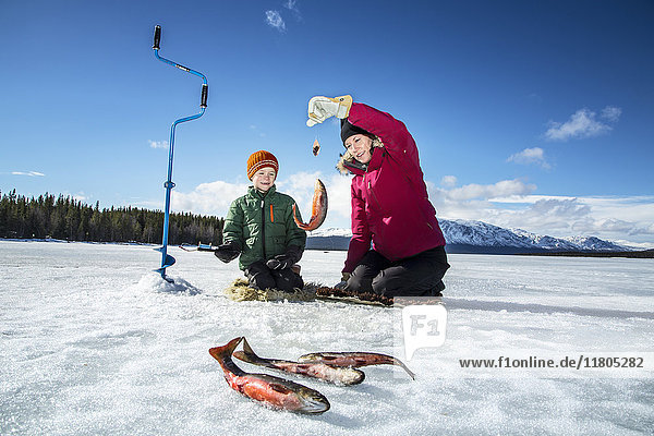 Mutter mit Sohn beim Eisfischen