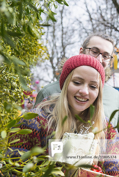Young couple with gifts and mistletoe twigs