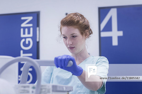 Female nurse holding part of X-ray equipment