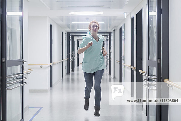 Female nurse running in hospital hallway