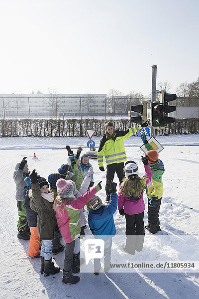 Man teaching road safety to children on snow field