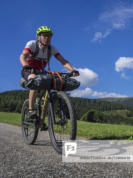 Mountain biker riding on a road near Neuenweg