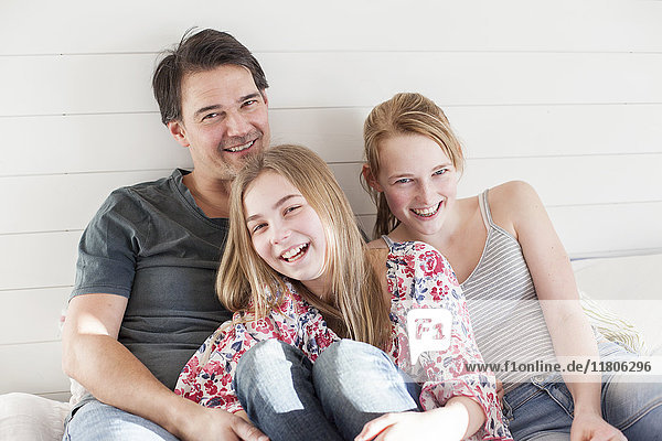 Father smiling with two daughters
