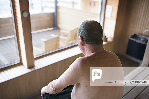 Älterer Mann sitzt in der Sauna