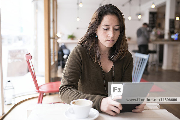 Woman using digital tablet in cafe
