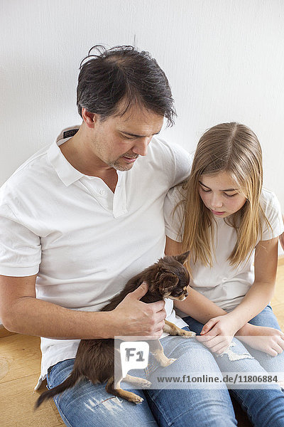 Vater und Tochter spielen mit Hund