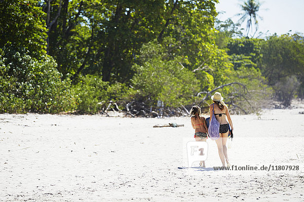 Mother with daughter walking on beach