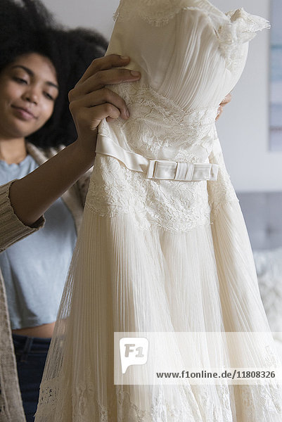 Afroamerikanische Frau hält Hochzeitskleid
