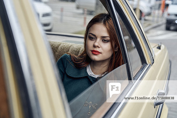 Nachdenkliche kaukasische Frau auf dem Rücksitz eines Autos