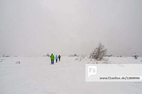 Kaukasische Frauen wandern in einem abgelegenen Feld im Winter