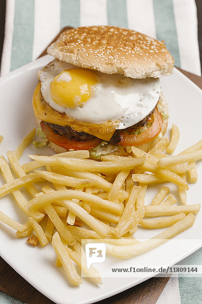 Cheeseburger mit Ei und Pommes frites