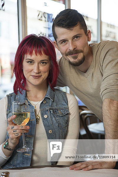 Porträt eines kaukasischen Paares mit Weißwein im Restaurant