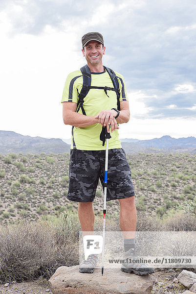 Portrait of smiling Hispanic man hiking in desert