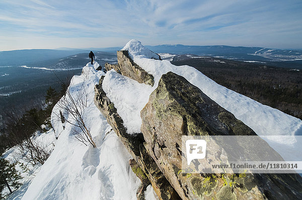 Kaukasischer Mann beim Wandern auf einem Berg im Winter