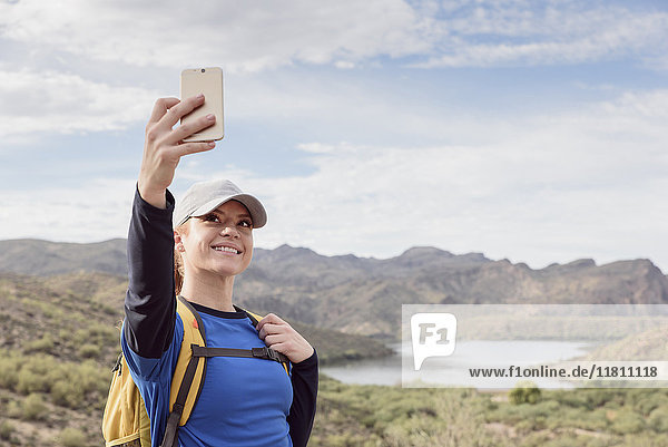Kaukasische Frau posiert für Handy-Selfie in der Wüste