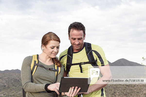 Wanderer mit digitalem Tablet in der Wüste