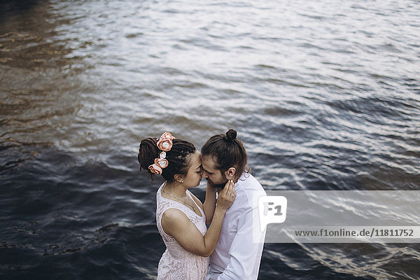 Middle Eastern couple embracing near water