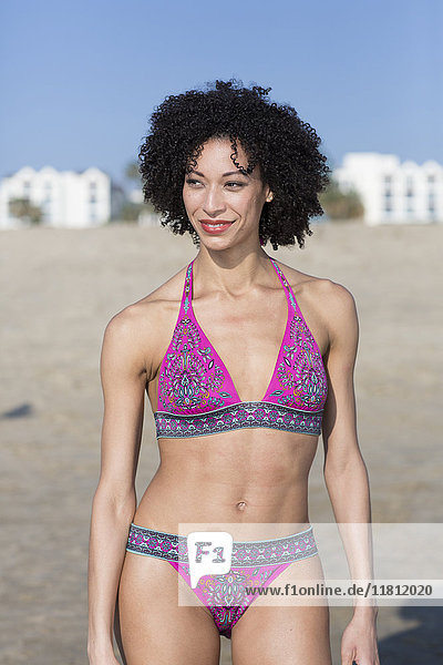 Mixed Race Frau im Bikini am Strand stehend