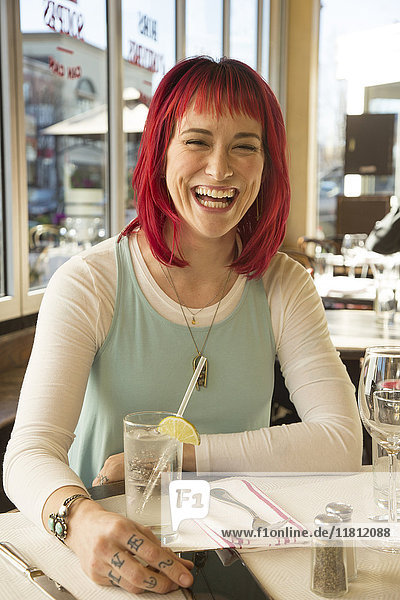 Caucasian woman laughing in restaurant