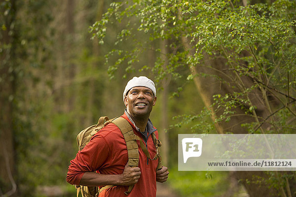 African American man standing in forest carrying backpack
