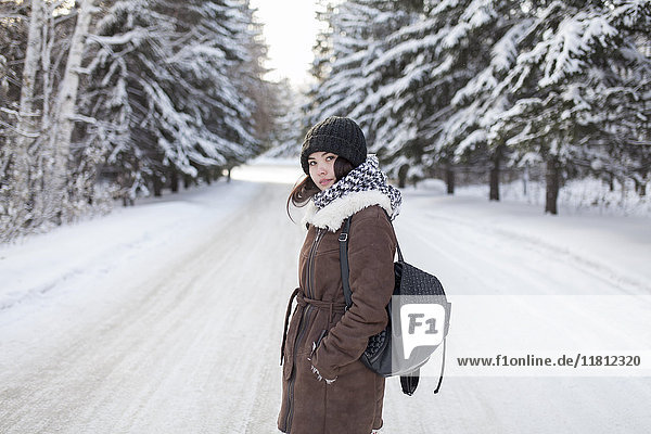 Asiatische Frau mit Rucksack auf verschneiter Straße