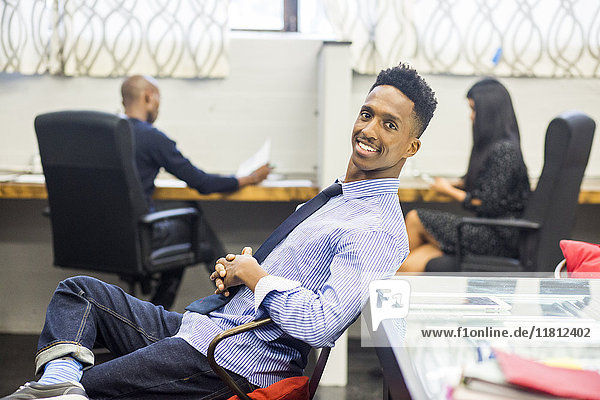 Portrait of smiling Black man relaxing in office