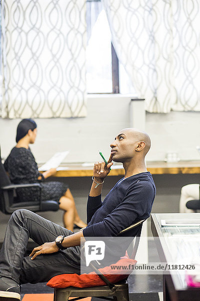 Porträt eines nachdenklichen afroamerikanischen Mannes  der in einem Büro sitzt