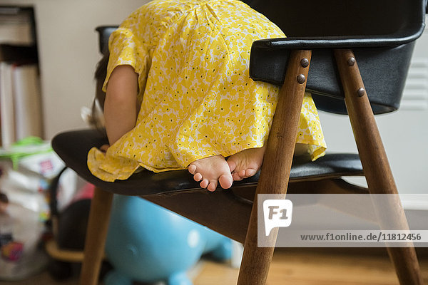 Barfuß kaukasischen Baby-Mädchen liegen auf Stuhl