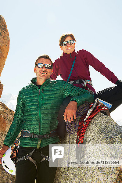 Porträt eines Paares mittlerer Erwachsener mit Bergsteigerausrüstung lächelnd