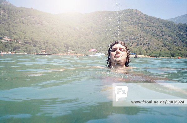 Man swimming and blowing water from mouth