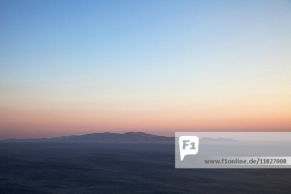 Seelandschaft und Fernsicht auf die Insel Andros von der Insel Tinos bei Sonnenuntergang  Griechenland