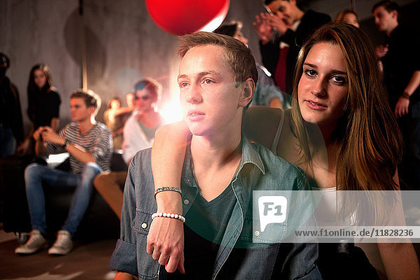 Couple in nightclub teenage girl with arm around teenage boy