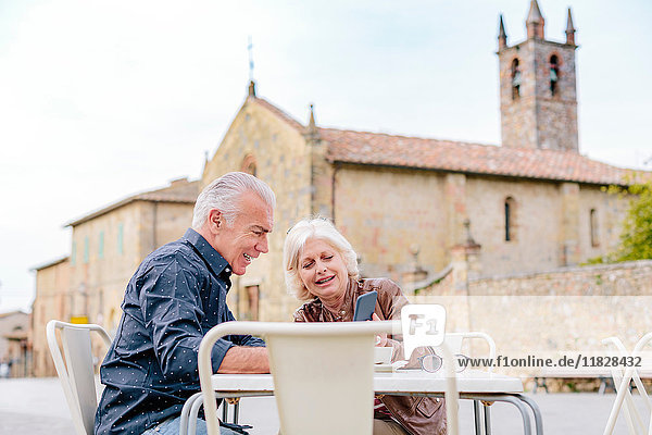 Touristenpaar betrachtet Smartphone im Bürgersteig-Café  Siena  Toskana  Italien