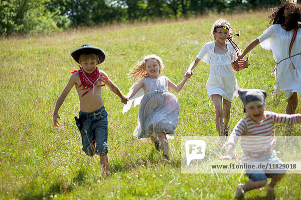 Kinder in Kostümen laufen im Feld