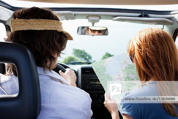 Ehepaar im Auto schaut auf die Karte