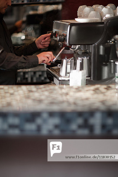 Barista using espresso machine at cafe