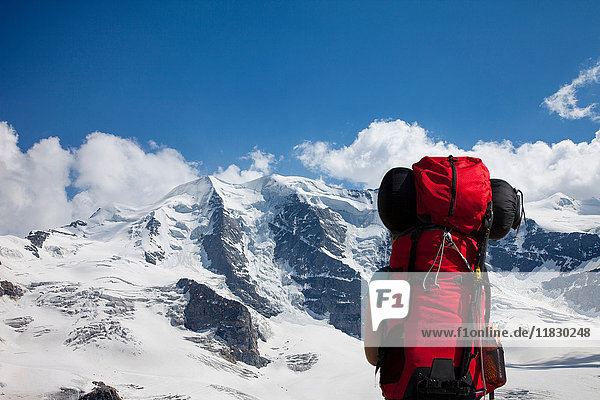 Rucksacktourist bewundert verschneite Berge