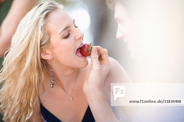 Mann füttert Freundin Erdbeere