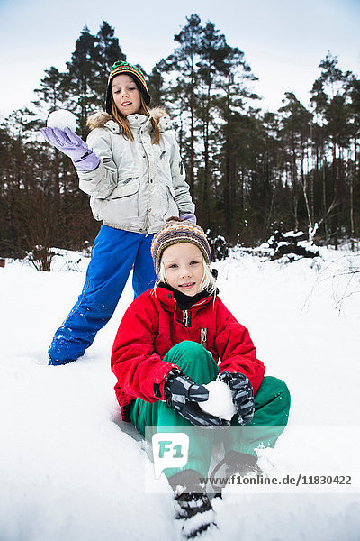 Children making snowballs in snow