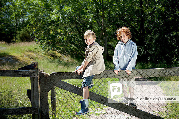 Children climbing wooden fence outdoors