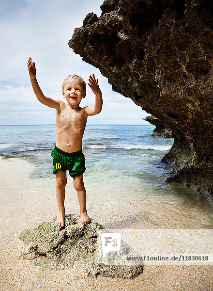 Boy playing on rocks on beach
