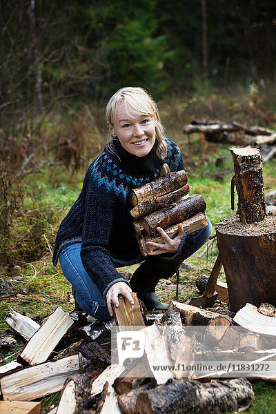 Frau sammelt Brennholz im Wald