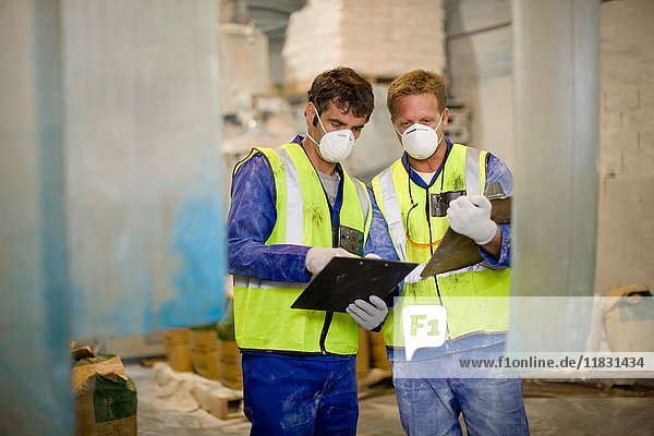 Workers in masks talking in factory