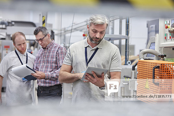 Männlicher Supervisor mit digitalem Tablett in der Glasfaserfabrik