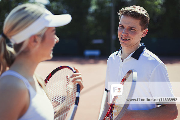 Tennisspielerinnen und Tennisspieler im Gespräch  die Tennisschläger halten